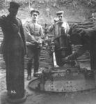 25 cm schwerer Minenwerfer in a trench. The left soldier is showing a 25 cm mine shell as used in the artillery piece.