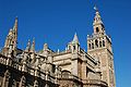 Catedral de Sevilla, 1403-1593. Es el edificio gótico de mayor superficie (23.457 m2), y el tercer templo cristiano (tras San Pedro de Roma y San Pablo de Londres). La Giralda (101 m) es su torre-campanario, cuya base es la torre-alminar de la anterior mezquita mayor, 1172-1198.[11]​