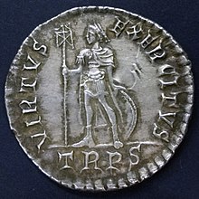 Moeda de prta mostrans um homem em pé com um estandarte e um escudo redondo atrás de suas pernas. Existe uma inscrição em torno da borda incluindo a sigla "TRPR" abaixo da figura.