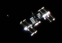 The International Space Station photographed by Vandebergh: "The image shows not only the ISS with very special lighting angle but also it shows activity around the ISS which is often the case. You see the Japanese Cargo Ship HTV-1 in its demonstration flight shortly before docking and just a few hundred meters below the ISS."