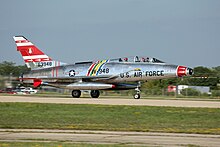 A North American F-100F single-engined two-seat jet fighter on runway.