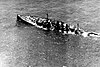 Aerial view of a large warship sinking by the stern