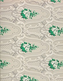 Detail of ornate wallpaper in a gray, white, and green design.