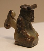 Miniature human figure kneeling on the ground