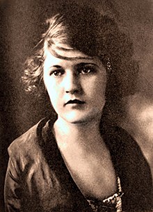 a sepia photograph of a woman head and shoulders. Her hair is cut short.