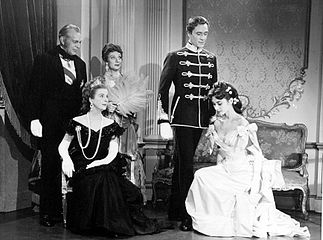 Raymond Massey, Diana Wynyard (seated), Judith Evelyn, Mel Ferrer, and Audrey Hepburn in Mayerling (1957)