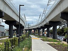 The newly elevated Reservoir railway station showing the project's elevated designs with a road in the foreground.