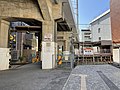 駅へ続く踏切と看板 高架に沿った手前側に新松戸駅出入口がある（2022年6月）