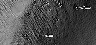 Close view of boulders sitting in pits, as seen by HiRISE under HiWish program