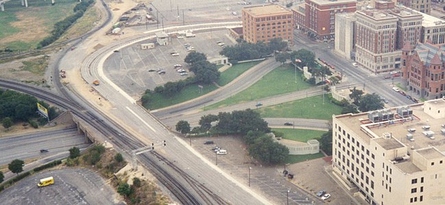 A similar view of Dealey Plaza from the mid-1990s also includes the Art Deco Terminal Annex Federal Building in the lower-right foreground, the former Dallas County Courthouse made of red sandstone, and the Dallas County Criminal Courts Building adjacent to the Dallas County Records Building.