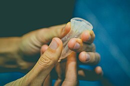 A cup being folded and squished into a cylindrical shape.