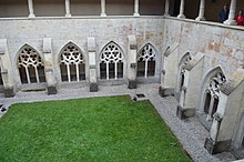 Photo prise de plongée d'un cloître avec un carré de verdure au centre