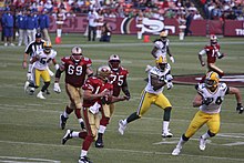 Green Bay Packers players chasing San Francisco 49ers players on a field