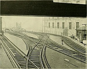Four tracks are shown leading out to the right, before correcting themselves and going straight. Various crisscrossing occurs between them, and an additional siding leads to the tower.