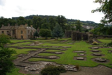 Photographie couleur d'un parc aménagé avec des ruines à fleur de sol.