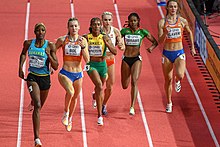 Photo of Femke Bol sprinting in second position with five other competitors