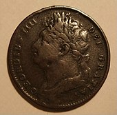 A worn copper coin with a bust of a heavyset man on it