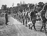 Disarmed Japanese troops marching towards a prisoner of war compound in Api after surrendering to the Australians on 8 October 1945