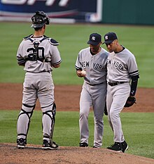 Wide shot of catcher Jorge Posada to the left with pitcher Mariano Rivera and shortstop Derek Jeter talking on the pitcher's mound.