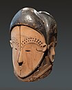 Masque heaume ngontang. M’fan. République gabonaise, 19e s. Bois, pigments dont kaolin, laiton, fragment de miroir. H. 31 cm[41]