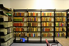 Several wall-mounted bookshelves contain books of various colors