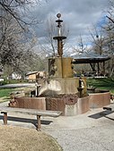 Water fountain constructed from old oil well drilling parts, located in the town's park.