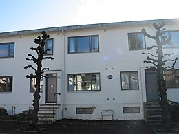 photograph of a two-storey, white, mid-terrace house