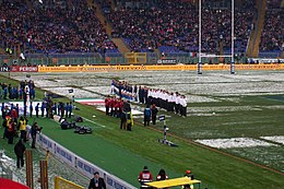 Two teams, lined up on a snow-covered pitch