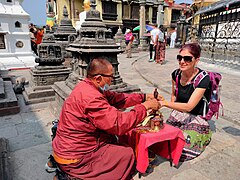 Buddhist priest performing ritual with a tourist