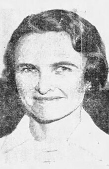 A smiling woman with pale skin and dark, wavy hair styled in a short bob.