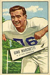 A trading card with Marchetti smiling in front of trees and an upright