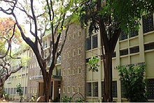 a collegiate architecture-style building with some trees around it.