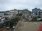 Broad street in Monrovia. The Ducor Hotel is visible on the hilltop in the background.