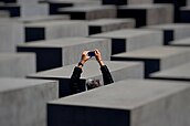 Tourist taking a picture at the Berlin Holocaust memorial