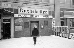 Snowy B&W image of the venue with a woman (Aimee Mann) standing in front