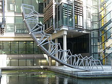 The Rolling Bridge at Paddington is lifted. It is in an unusual curved shape, with one end lifted into the air.