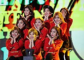 Twice performing on stage in red stage outfits