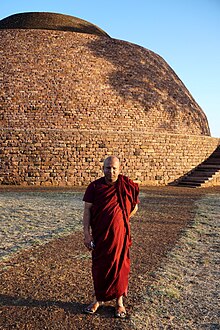 A Buddhist monk in front of the great stupa of Satdhara.