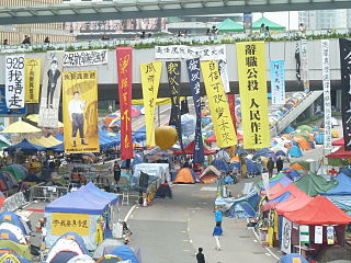 To the left, Xi Jinping banner amidst others on the Harcourt Road pedestrian bridge