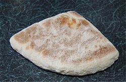 flat, triangular bread with pale surface irregularly covered with browning.