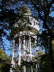 Château d'eau métallique vu à travers les arbres.