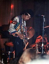Color photo on Hendrix on stage with guitar