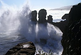 Vague déferlant sur la côte.