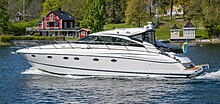 In the foreground, a large, white motor yacht on the sea, with an island in the background.