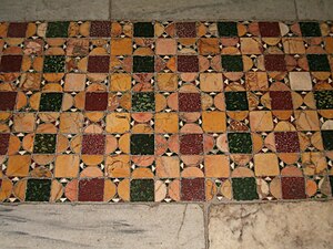 Marbre jaune antique réemployé au Moyen Âge dans un pavement cosmatesque de l'église Santa Maria in Cosmedin, Rome