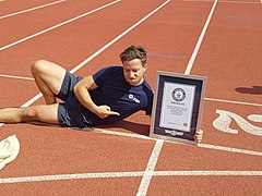 Stephen Wildish et son certificat du Guinness World Records pour son record du monde au 100 mètres en sac (26,22 s en 2017)[6],[7].