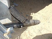 A wye-joining a perforated and solid corrugated pipe to a buried solid outlet