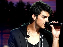 Joe Jonas singing on a mic