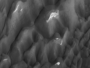 Lyot Crater Dunes, as seen by HiRISE. Click on image to see light-toned deposits and dust devil tracks.