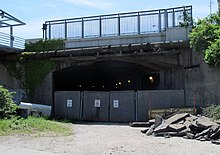 A fenced-off tunnel portal with no tracks